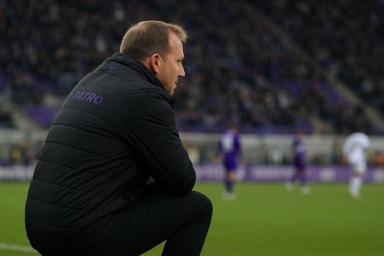 Coach van Patro Eisden langs het veld tijdens een competitiewedstrijd