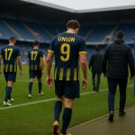 Sfeerbeeld in een stadion na een wedstrijd, met stafleden aan de zijlijn