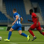 Actiebeeld in een stadion met een speler in aanvallende actie, gelinkt aan de transferpiste van KRC Genk.