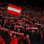 Supporters van Standard Luik op de tribune tijdens een wedstrijd, met sfeerbeelden zonder herkenbare gezichten.