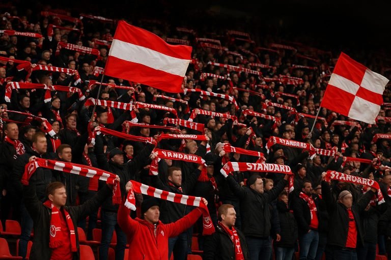 Supporters van Standard Luik op de tribune tijdens een wedstrijd, met sfeerbeelden zonder herkenbare gezichten.