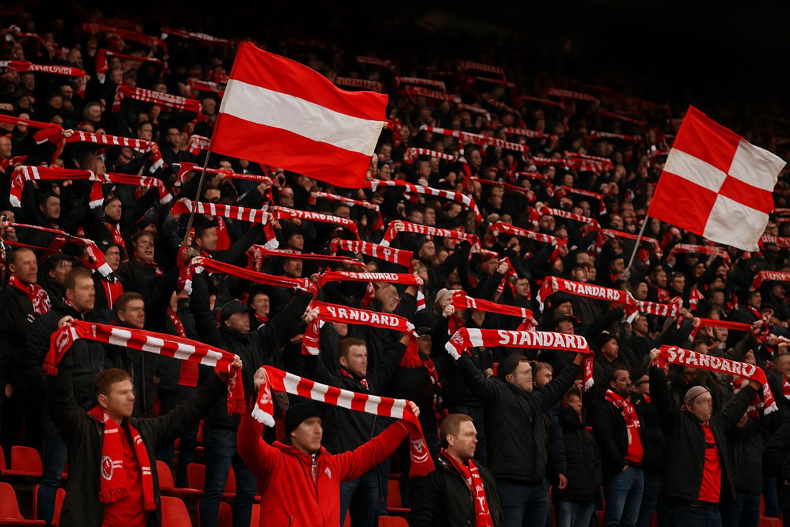 Supporters van Standard Luik op de tribune tijdens een wedstrijd, met sfeerbeelden zonder herkenbare gezichten.