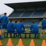Sfeerbeeld bij KRC Genk met spelers op training en een bank op de achtergrond