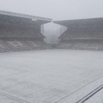 Besneeuwd voetbalveld in een leeg stadion in Nederland