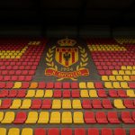 Stadion van KV Mechelen met tribunes in clubkleuren onder het licht