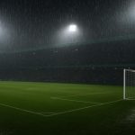 Regen op het voetbalveld onder felle stadionlichten, zonder herkenbare personen.