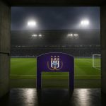 Sfeervol beeld van een stadiontunnel met avondlicht, zonder herkenbare personen