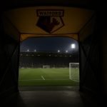 Sfeervol beeld van een stadiontunnel met lichtinval, zonder herkenbare personen.