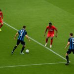 Distant match action met spelers van Club Brugge in beweging, zonder herkenbare gezichten.
