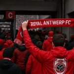 Supporters van Royal Antwerp FC stappen het stadion binnen in rood-witte kleuren