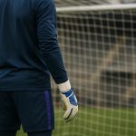 Een doelman op training bij RSC Anderlecht met handschoenen en een doelnet op de achtergrond