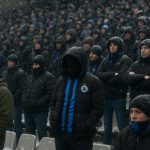 Supporters van Club Brugge in een besneeuwd stadion tijdens een uitwedstrijd, zonder herkenbare gezichten.