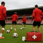 Training bij Standard Luik met spelers en medische staf op de achtergrond in Sclessin