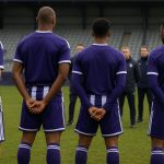 Spelers van RSC Anderlecht vieren samen een doelpunt in het stadion, met onherkenbare gezichten.