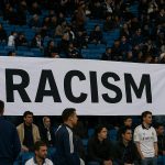 Supporters van Real Madrid tonen een groot antiracisme-spandoek in het Bernabéu