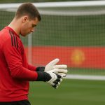 Senne Lammens op training bij Manchester United, met keepershandschoenen en een doel op de achtergrond.