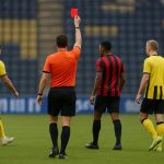Spelmoment in NAC Breda tegen Excelsior Rotterdam met de scheidsrechter in beeld na een rode kaart, gezien vanop afstand.
