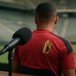 Opnamesfeer in een podcaststudio met microfoon en een speler in de achtergrond onscherp