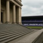 Neutrale sfeerfoto met het stadion van RSC Anderlecht en een gerechtsgebouw op de achtergrond, zonder herkenbare gezichten.