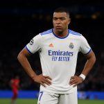 Sfeerbeeld in een Champions League-stadion tijdens een avondmatch, met spelers op de achtergrond zonder herkenbare gezichten.