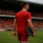 Een speler van Royal Antwerp FC op het veld in het Bosuilstadion, gezien vanop afstand zonder herkenbare gezichten.