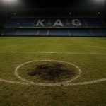 Sfeerbeeld van het Jan Breydelstadion met focus op het veld en sporen van vandalisme