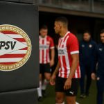 Spelers van PSV vieren een doelpunt in het stadion, met focus op sfeer en beweging zonder herkenbare gezichten.