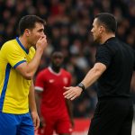 Spelers van Real Madrid en Benfica discussiëren met de scheidsrechter na een incident op het veld.