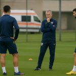 Beeld van de Roemeense nationale ploeg in trainingscontext, met medisch personeel op de achtergrond.