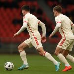 Spelers van België en de Verenigde Staten in een duel met gelijkaardige tenues op de achtergrond