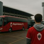 Lege supportersbussen van Royal Antwerp FC aan een parkeerzone bij een stadion, zonder herkenbare gezichten.