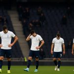Spelers van Tottenham Hotspur stappen ontgoocheld van het veld in een bijna leeg stadion