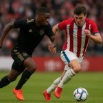Mika Godts van Ajax in actie tijdens een uitmatch, in volle loopduel