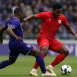 Spelers van RSC Anderlecht in een stevig duel op het middenveld tijdens een wedstrijd.