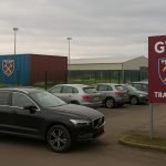 Omgeving van een trainingscomplex met geparkeerde wagens, zonder herkenbare personen