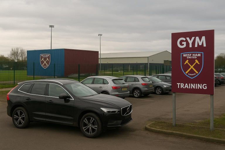 Omgeving van een trainingscomplex met geparkeerde wagens, zonder herkenbare personen