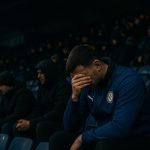Supporters van KAA Gent op de tribunes in de Planet Group arena in een ingetogen rouwsfeer