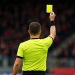 Scheidsrechter toont een gele kaart in een stadion van de Jupiler Pro League