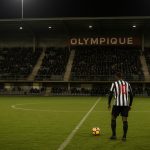 Sfeervol beeld van een stadionomgeving bij een match in tweede klasse zonder herkenbare gezichten