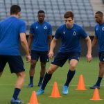 Spelers van Club Brugge tijdens een training, met focus op de defensiezone op het veld.