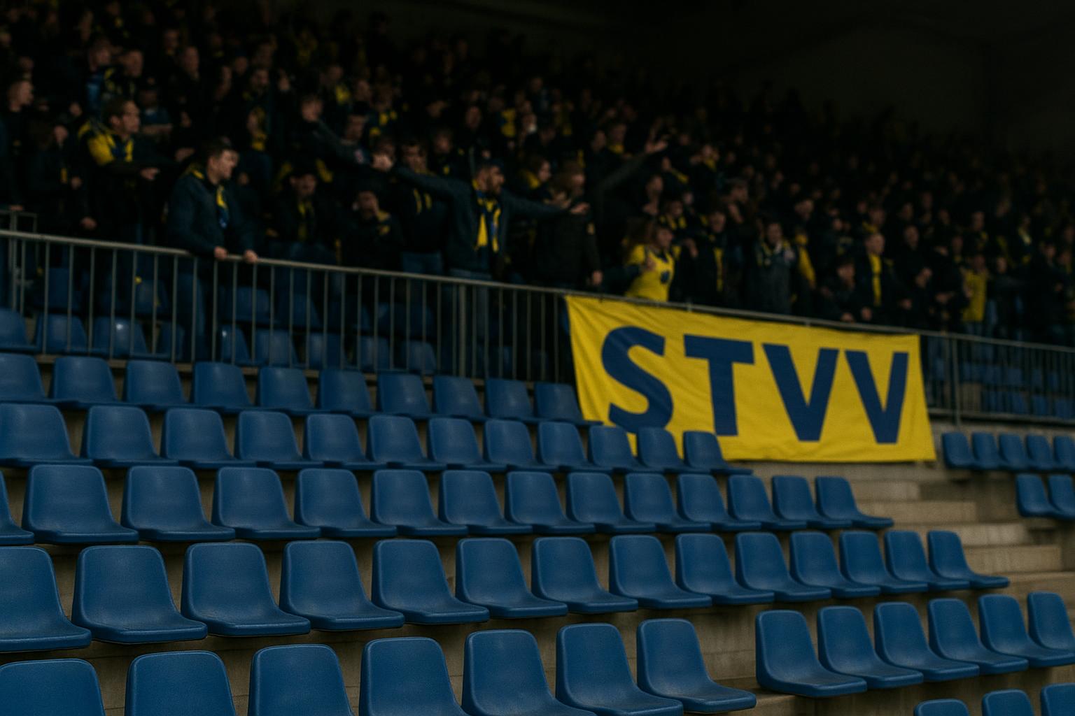 Tribunes in het stadion van STVV tijdens een wedstrijd, zonder herkenbare gezichten.