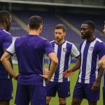 Spelers van RSC Anderlecht vieren samen op het veld in een wedstrijdsetting.