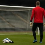 Doelman in trainingsoutfit bij een oefensessie, gezien vanop afstand.
