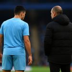 Rodri van Manchester City op het veld met Pep Guardiola op de achtergrond