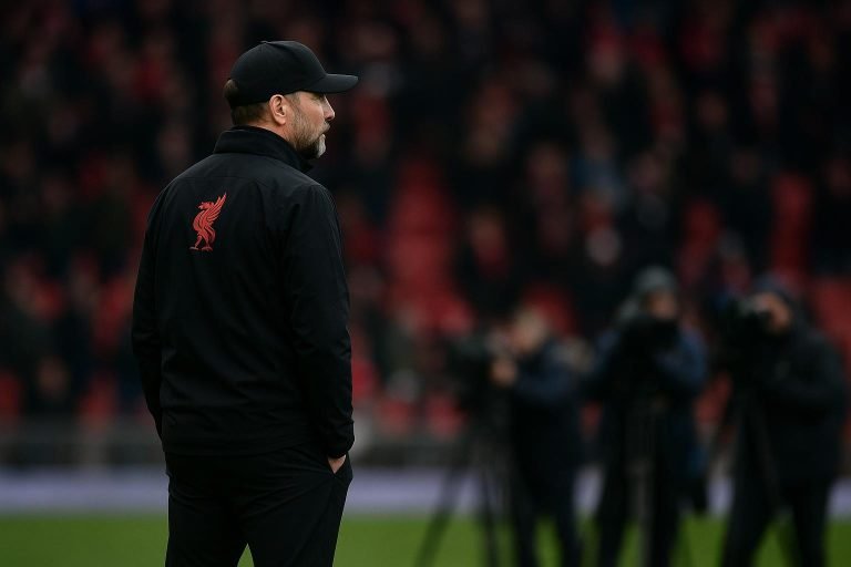 Een coach van Liverpool langs de zijlijn, met spelers onscherp op de achtergrond