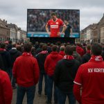 Supporters van KV Kortrijk volgen samen een wedstrijd op een groot scherm