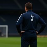 Trainer in Tottenham-kledij op het trainingsveld, gezien van achteren