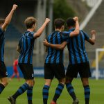 Spelers van Club NXT vieren na een wedstrijd in de Youth League