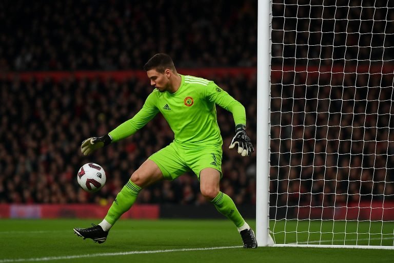 Senne Lammens bij Manchester United in een Premier League-wedstrijd, met doelkader op de achtergrond