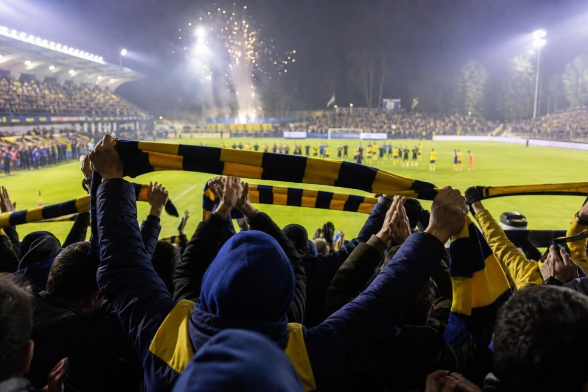 Supporters van Union Saint-Gilloise creëren een warme afscheidssfeer in het Mariënstadion